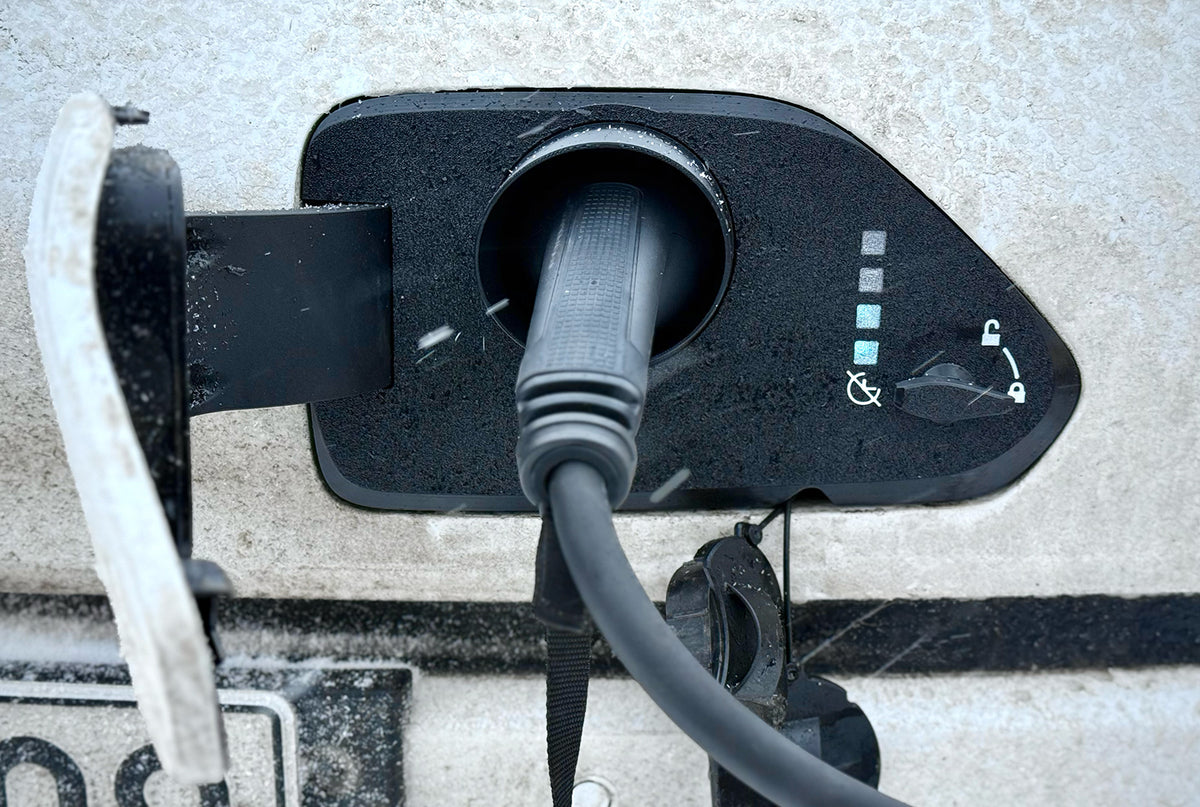 Snødeksel til ladeport på Hyundai Kona Electric 2024 – nærbilde med ladekabel tilkoblet