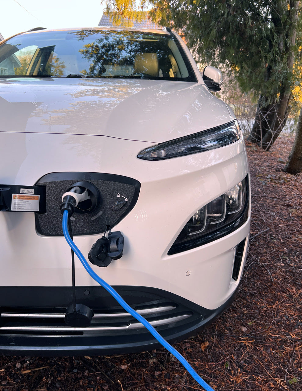 Hyundai Kona Electric 2021–2023 lader med snødeksel montert – front og ladeport synlig for modellsjekk
